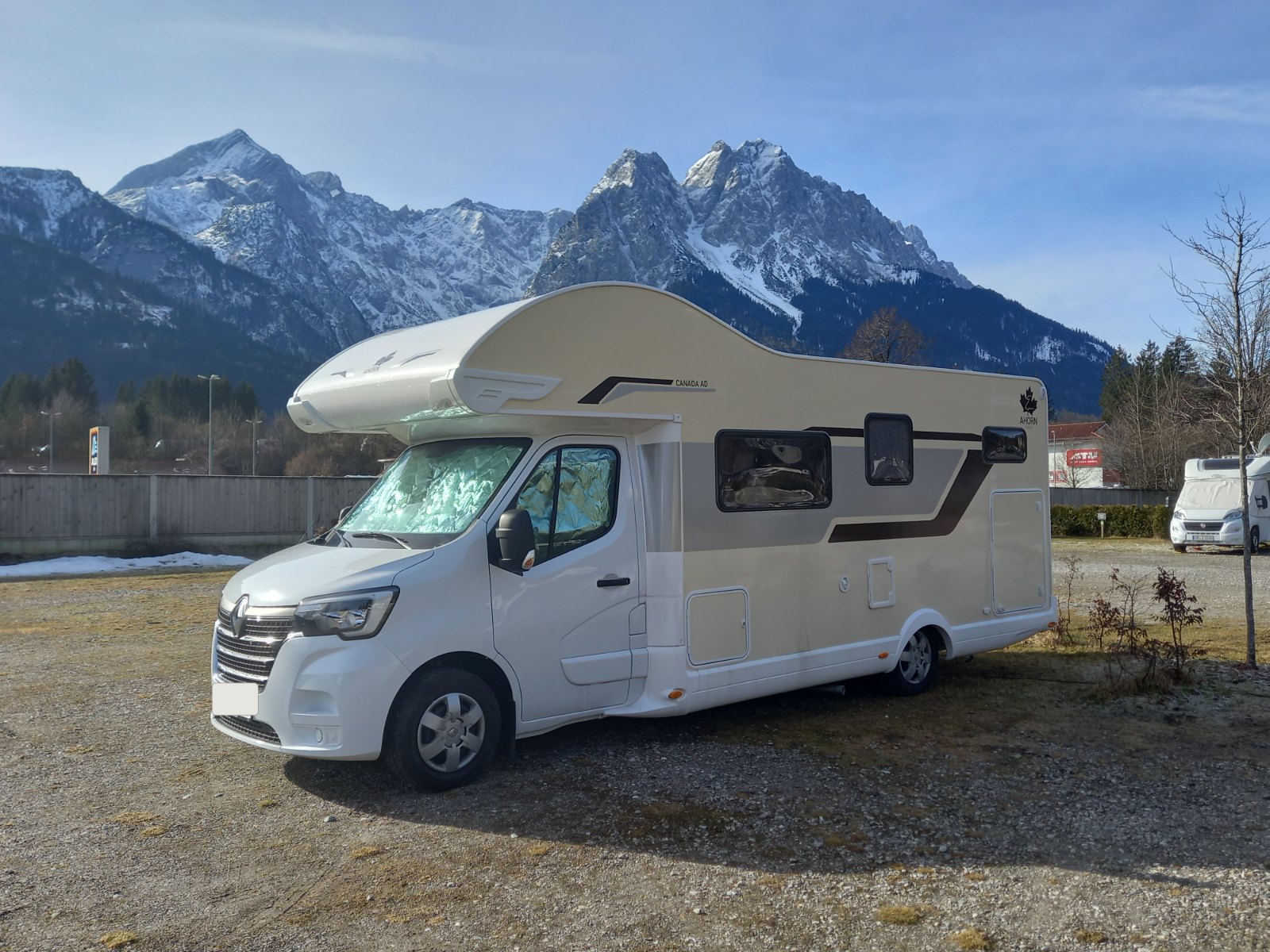 Ahorn Canada AD auf einem Stellplatz vor schneebedecktem Bergmassiv